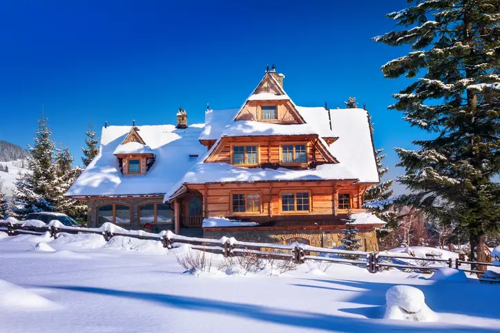 Winter morning view of wooden residential house covered by the snow