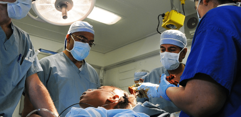 Doctors performing surgery on patient after car accident.
